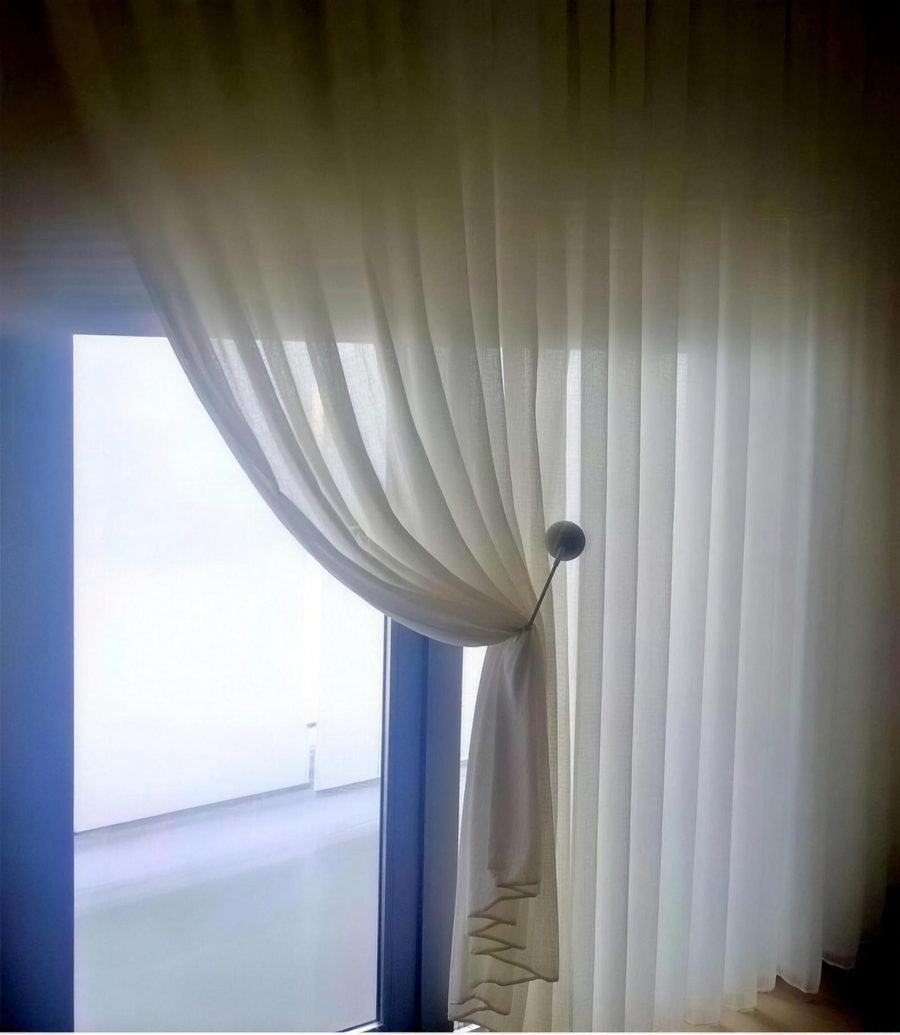 Hvidt transparent gardin bundet op med gardinholder